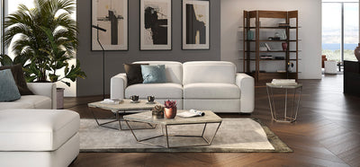 Living room setting with white leather Diesis Natuzzi Italia sofas, dark wooden floors, grey walls and coffee table.